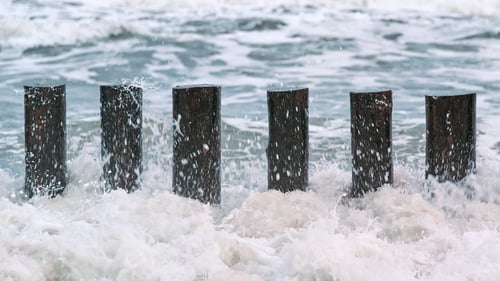 Preview: High wooden breakwaters in foaming sea waves
