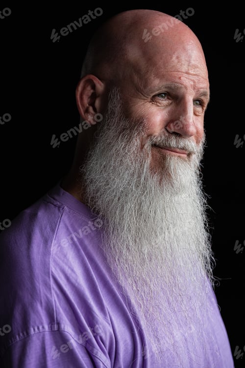 Preview: Portrait of man with long gray beard wearing purple t-shirt close-up shot