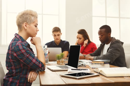 Preview: Coworking Or Education. Serious Young Woman Working With Laptop At Modern Office, Colleagues