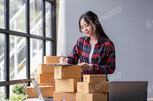 Preview: Startup happy Asian woman sme business owner work with prepare parcel delivery boxs at home, SME sup