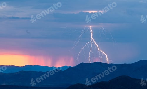 Preview: Stunning lightning strike over a mountain range at sunset with vibrant colors in the sky.