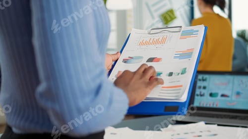 Preview: Closeup of african american woman hands holding clipboard with financial data and sales charts