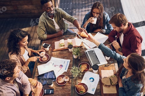 Preview: Shot of a group of creative workers having a meeting over lunch in a cafe