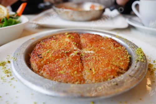 Preview: kunafa with a wipe cream on a plate .