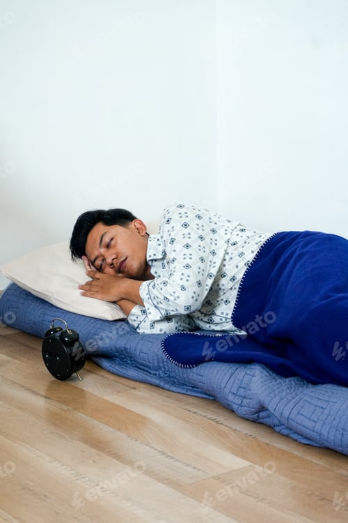 Preview: Portrait Of Young Asian Man Peacefully Sleeping On Floor With Alarm Clock
