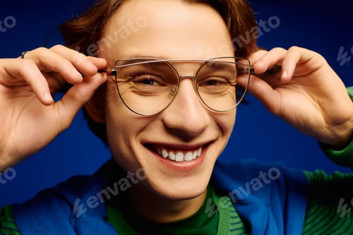 Preview: Young man showcases trendy eyewear with stylish flair in vibrant setting