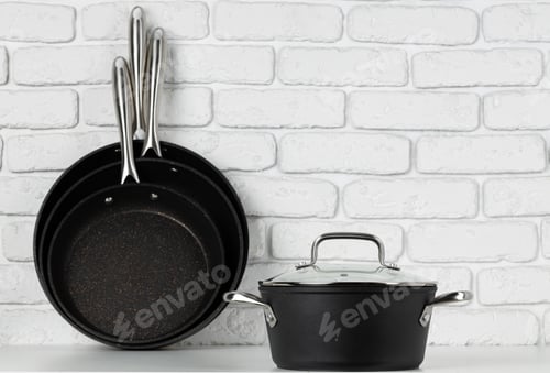 Preview: Set of cookware on table against white brick wall