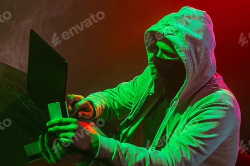 Preview: Hooded Computer Hacker Stealing Information With Laptop