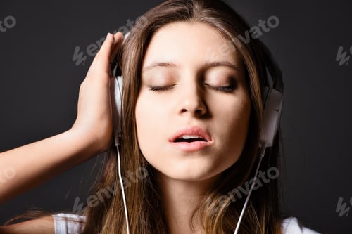 Preview: Music gives the soul a voice. Shot of a young woman listening to music against a studio background.