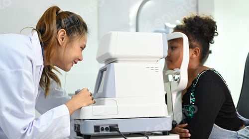 Preview: Image of little girl checking eyesight on auto refractor in ophthalmologist clinic.