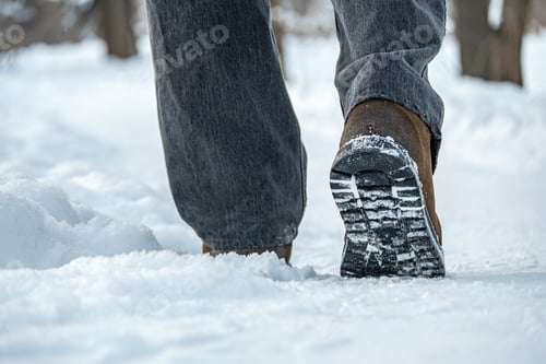 Preview: Winter boots walking on snow close up