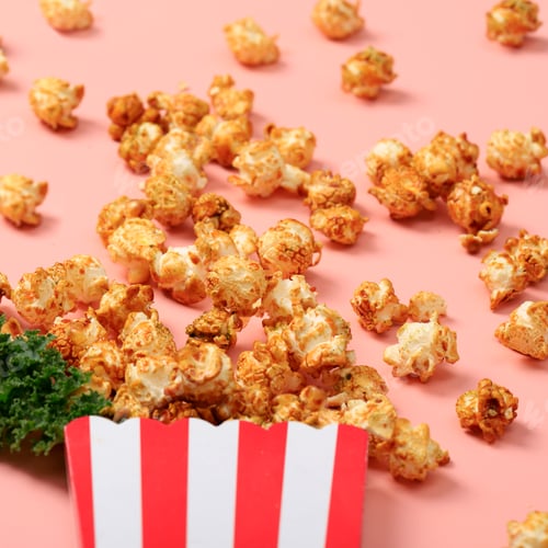 Preview: Delicious Caramel Popcorn Overflowing from Striped Container