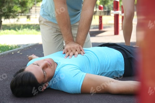 Preview: Passerby performing CPR on unconscious man outdoors. First aid