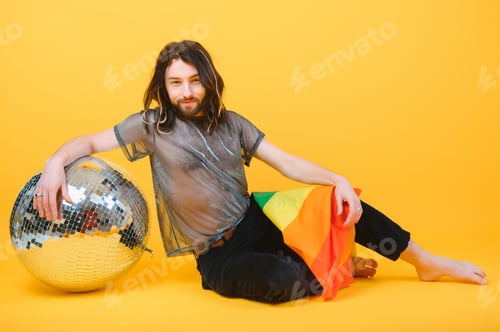 Preview: Gay man hold rainbow striped flag isolated on colored background studio portrait.