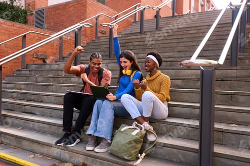 Preview: Diverse university students celebrating academic success on campus stairs
