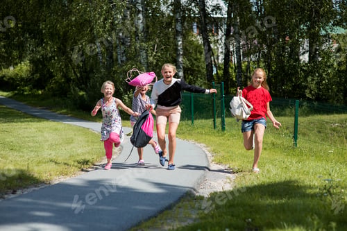 Preview: happy teenage schoolgirls run,jump, laugh and throw school bags in the air