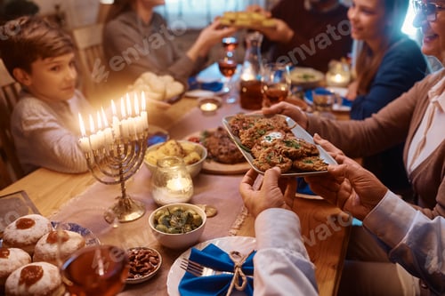 Preview: Close up of Jewish family having a meal together at dining table on Hanukkah.