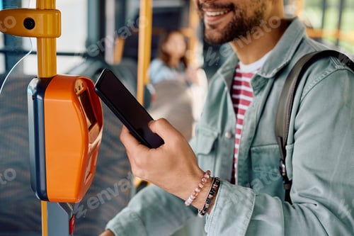 Preview: Close up of commuter validating card with smart phone while onboarding in a bus