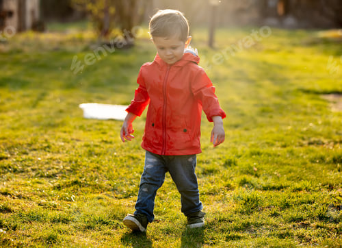 Preview: Funny toddler boy with wet hands at outdoor