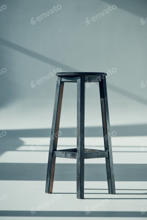 Preview: View of wooden bar stool with shadows on grey
