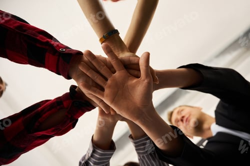 Preview: Bottom view hardworking colleagues folding hands together
