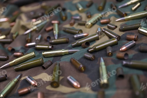 Preview: Many rifle bullets and cartridges on dark camouflage background