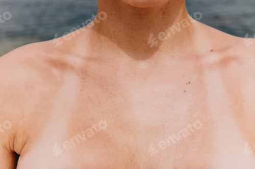 Preview: Close up of woman's chest with ocean in background