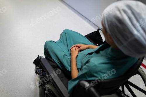 Preview: High angle view of a Caucasian female patient sitting on a wheelchair on the hospital corridor