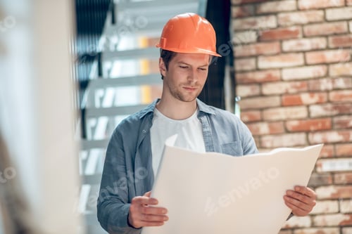 Preview: Man working with construction plan at building feature