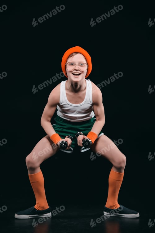 Preview: boy training with dumbbells isolated on black. athletics children concept