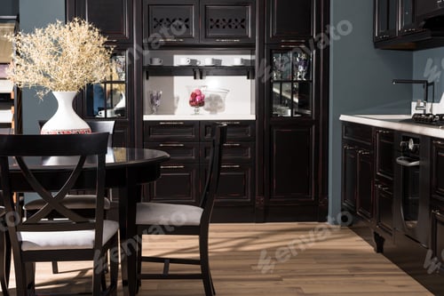 Preview: interior of modern dining room with black furniture and vase of dried flowers on table