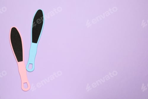 Preview: Colorful foot files on violet background, flat lay with space for text. Pedicure tools