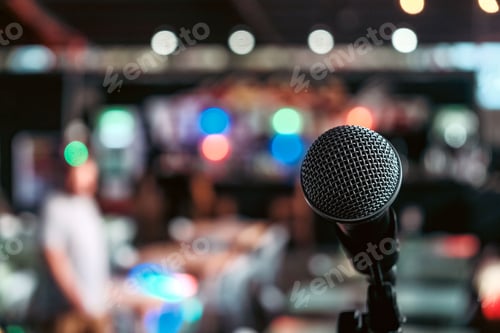 Preview: Black directional microphone on a tall stand in the center of a room