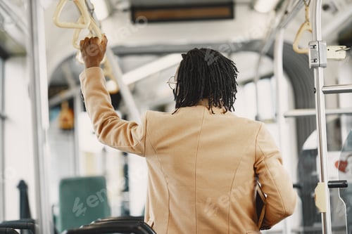 Vorschau: Junger afrikanischer Geschäftsmann steht in einem Bus