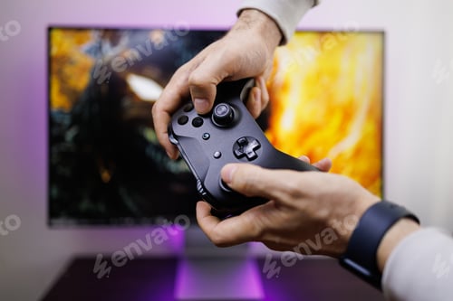 Preview: The man's hands are holding a gamepad that he's clutching. Video game gamepad in hand