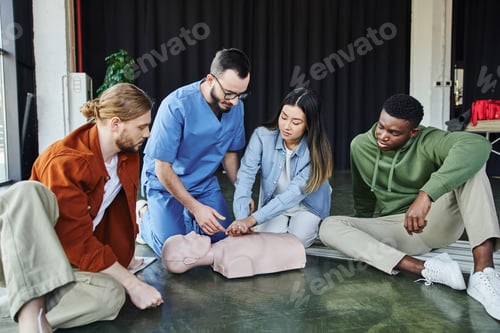 Preview: young asian woman practicing life-saving skills by doing chest compressions on CPR manikin near