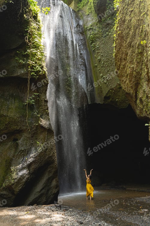 Preview: Relaxed young female person looking at waterfall