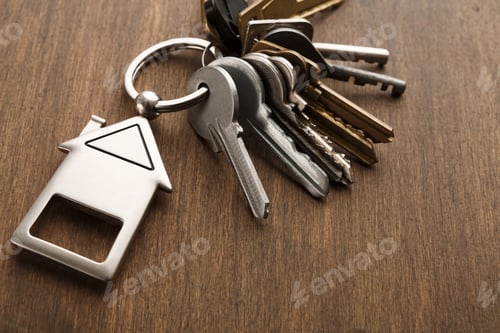 Preview: Bunch of keys with house shaped keychain on white wood