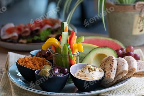 Preview: Plate of delicious traditional Ethiopian food and some vegetables on a wooden table