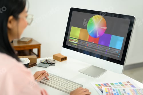 Preview: Female designer analyzing color schemes on computer screen for an interior project