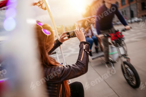 Preview: Woman photographing friends riding tricycle