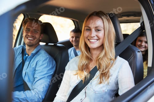 Preview: Young family going on holiday in a car look to camera