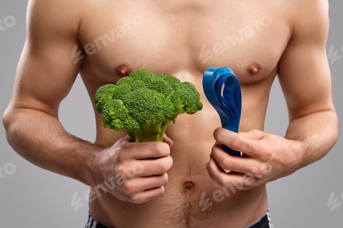 Preview: Crop muscular guy with broccoli and tape measure