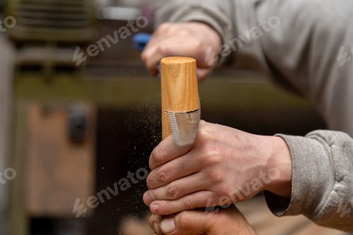 Preview: Closeup of carpenter cutting table leg with hand saw