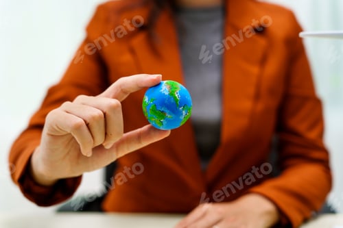 Preview: A businesswoman in a brown suit stands at a white desk with a world model, net zero 2050 reduce co2