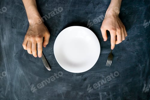Preview: top view of person's hands on the table with empty plate design mock up designs