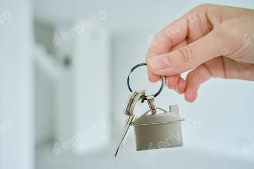 Preview: Hand holds house keys against new apartment