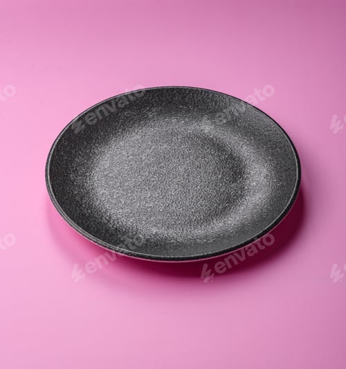 Preview: An empty round ceramic plate on a pink background as a kitchen utensil. An empty plate