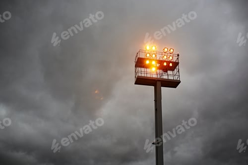 Preview: Airport floodlights against cloudy sky