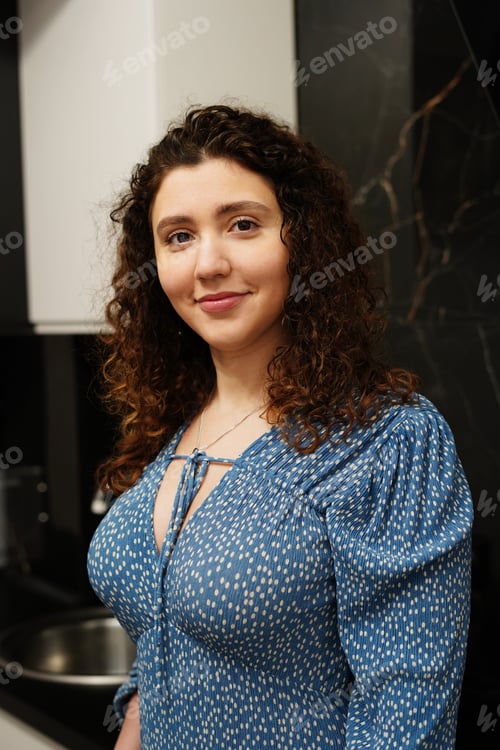 Preview: Natural Portrait Of Young Woman Smiling Indoors In Modern Kitchen Interior